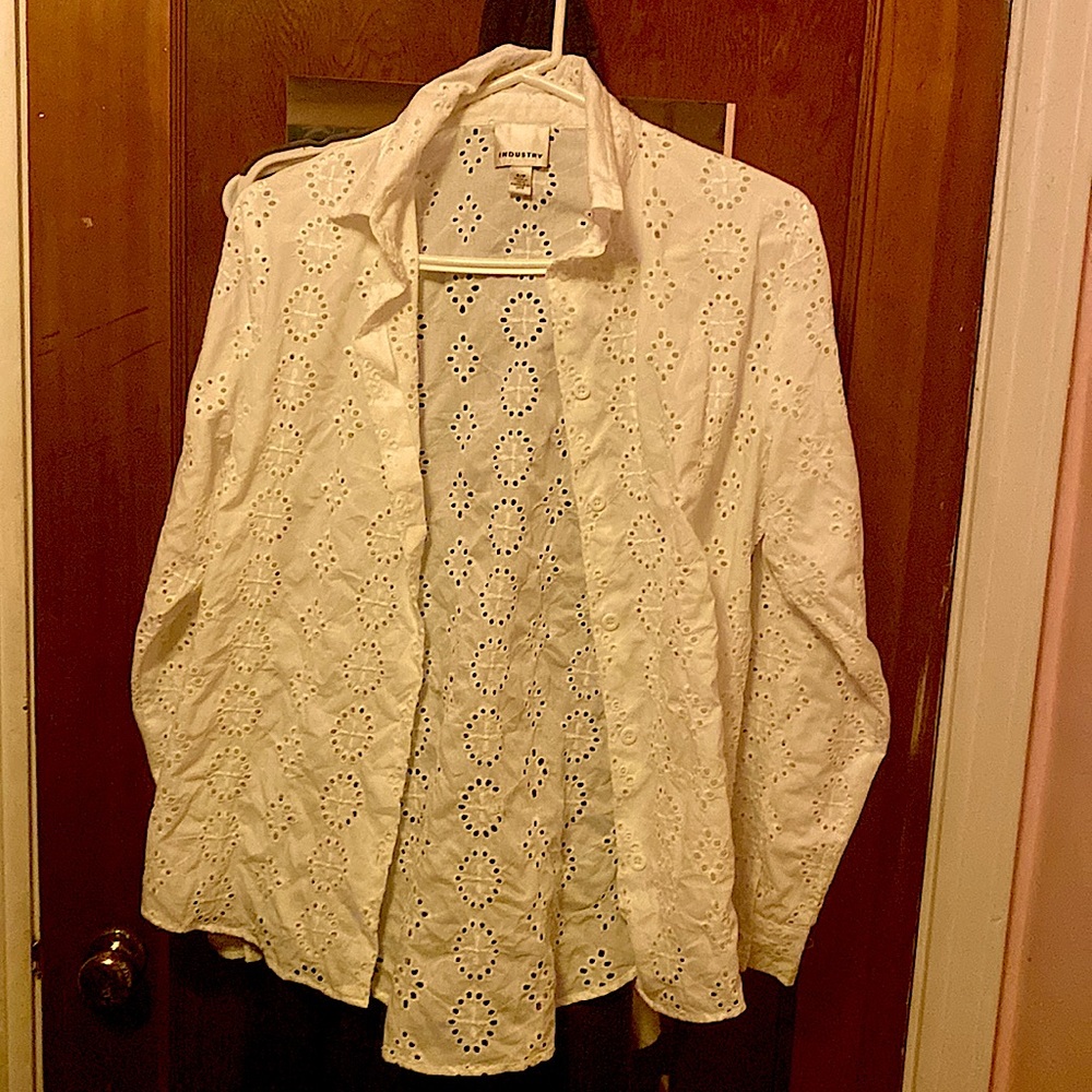 This is a button up white long sleeve shirt with buttons he cuffs.
